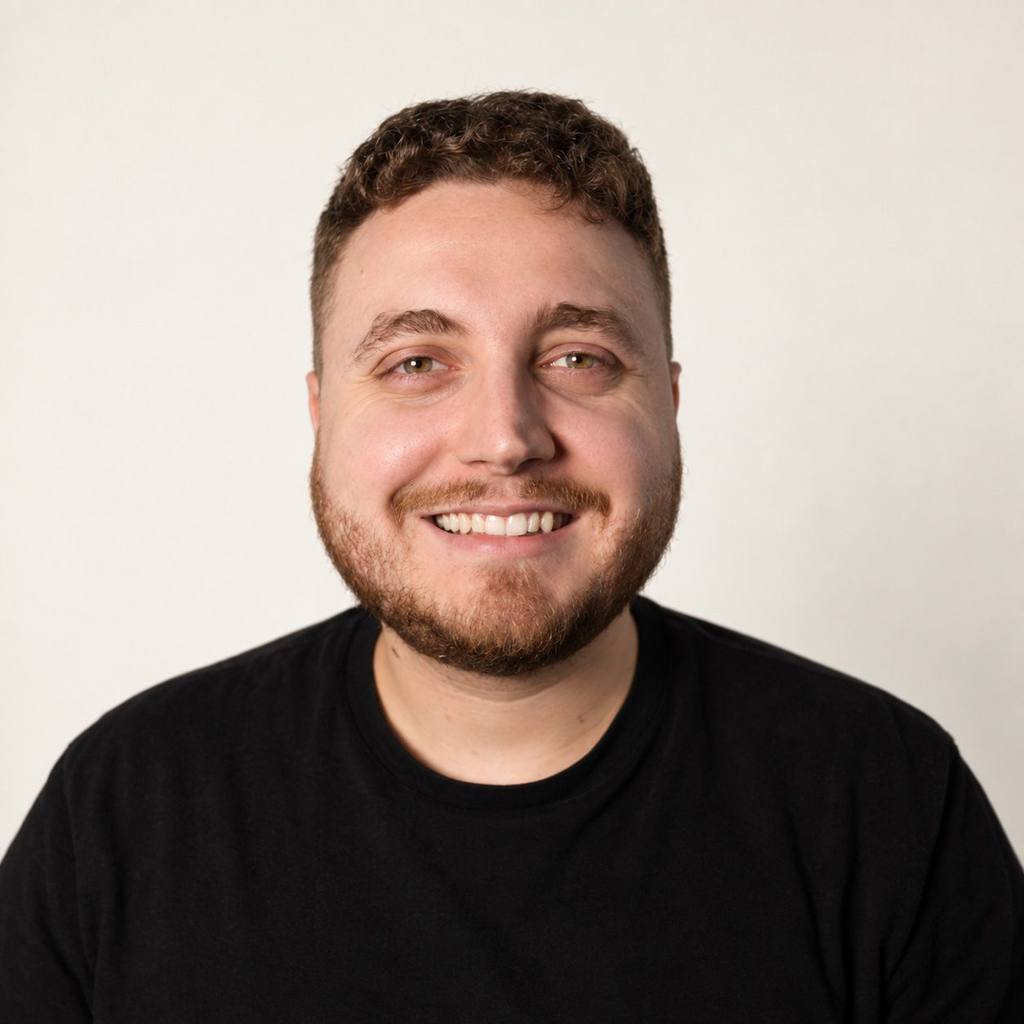 Portrait de face de Charles Patoine, souriant, sur fond clair.