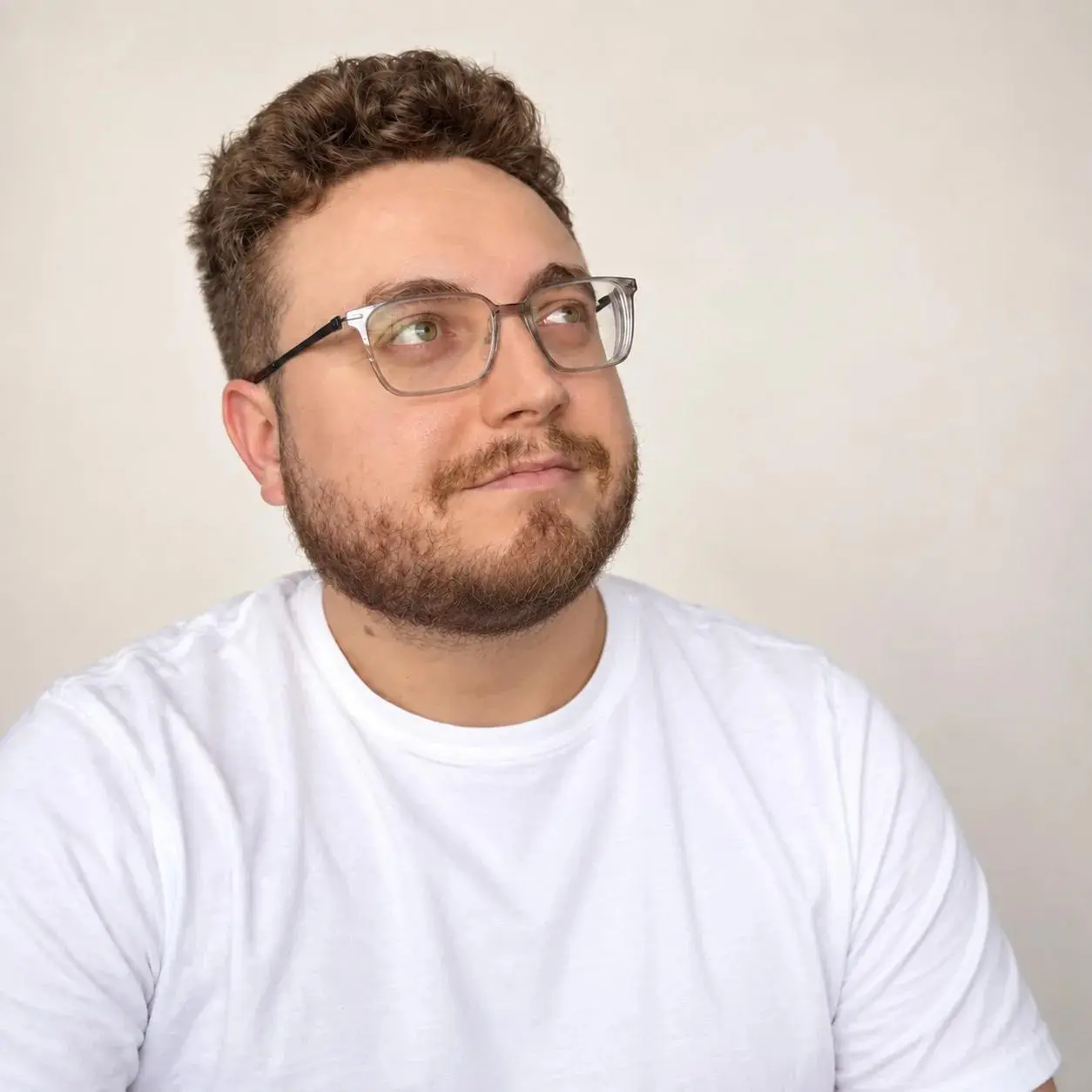 Portrait de Charles Patoine, avec lunettes et chandail blanc.